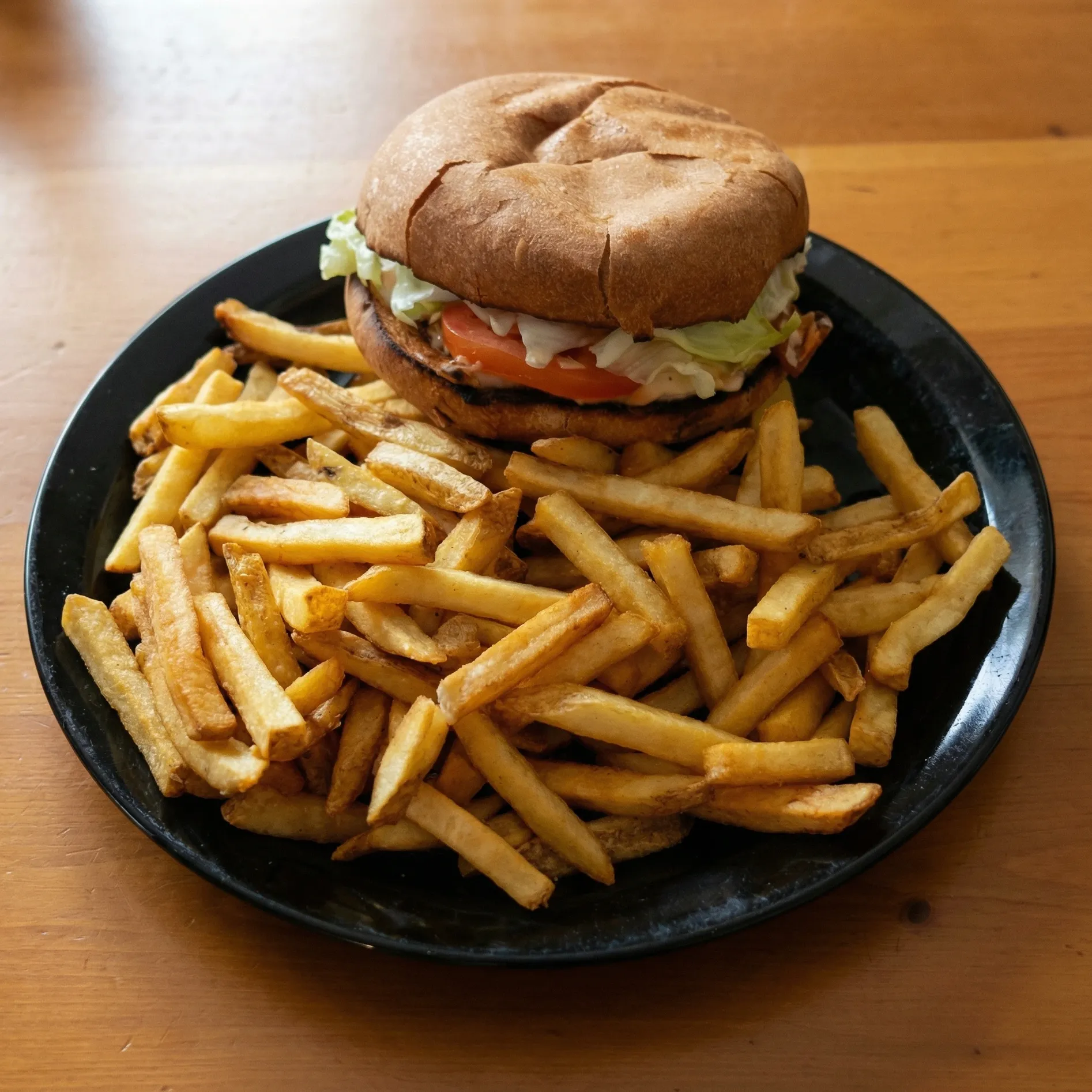 Grilled chicken burger with a side of fries at Capital Pizza Belle Rive Edmonton