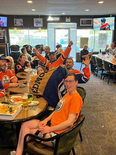 Dining room with booths, tables and TVs at Capital Pizza & Steak House in Belle Rive, Edmonton